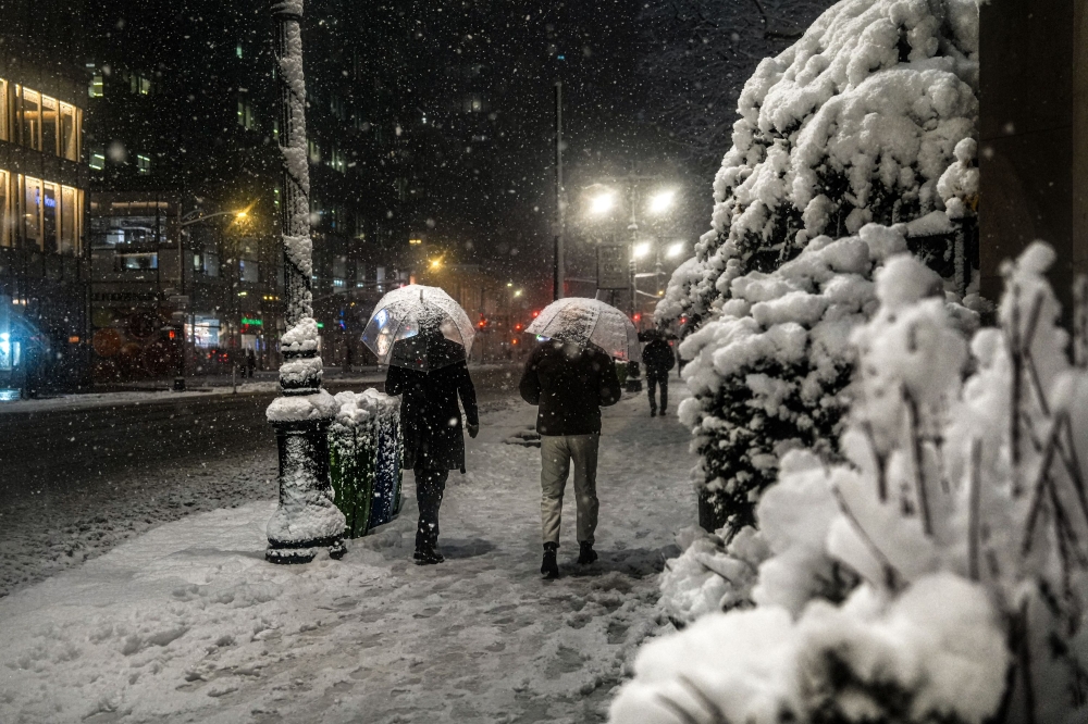 People walk through the snow during a city-wide travel ban on February 22, 2026, in New York City. A major winter storm has hit the Northeast and Mid-Atlantic regions bringing heavy snowfall and blizzard conditions with the potential of up to 23 inches of snow in New York City. — AFP pic