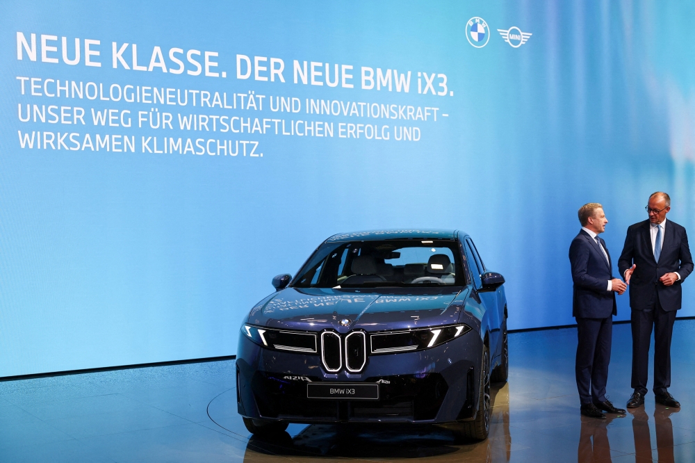BMW Group CEO Oliver Zipse talks with German Chancellor Friedrich Merz next to a BMW iX3 at the IAA Mobility 2025 auto show in Munich, Germany, in this file picture dated September 9, 2025. German car exports to China plunged by roughly a third in 2025, extending a steep decline that has wiped out more than half the sector’s shipments since their 2022 peak, according to a study released by the German Economic Institute (IW) on Tuesday. — Reuters pic 