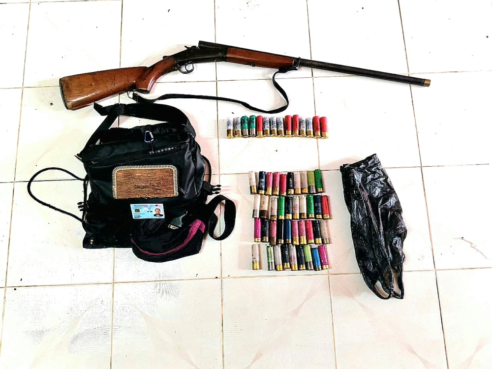 The shotgun and ammunition seized by police from the suspect. — Police pic