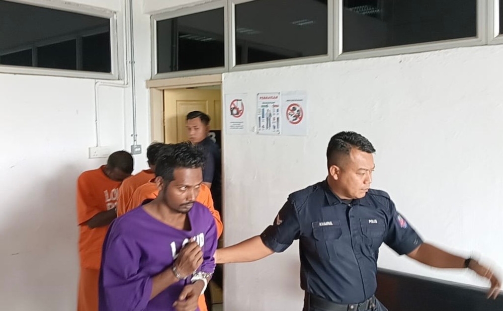 Rohingya refugee Rashidullah Mong Fumiyah, 35, being escorted by a policeman after he was charged in the Kota Tinggi Magistrates’ Court today for the murder of his pregnant wife and her unborn child, February 25, 2026. — Picture by Ben Tan