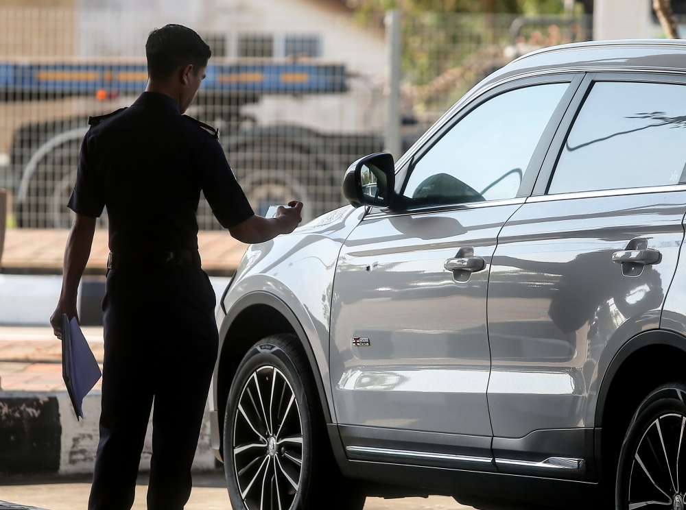 A police investigator examines Bukit Kayu Hitam AKPS commander SAC Mohd Nasaruddin Mohd Nasir’s car after it was fired upon in the early hours of February 25, 2026. — Bernama pic