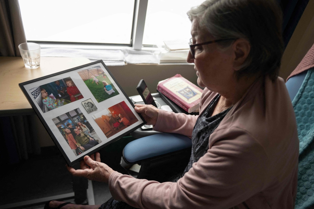 Rachel Fournier, who has requested medical assistance in dying due to a brain tumor, gazes at framed family photos at a palliative care center in Boucherville, Quebec Province, Canada, on February 20, 2026. — AFP pic