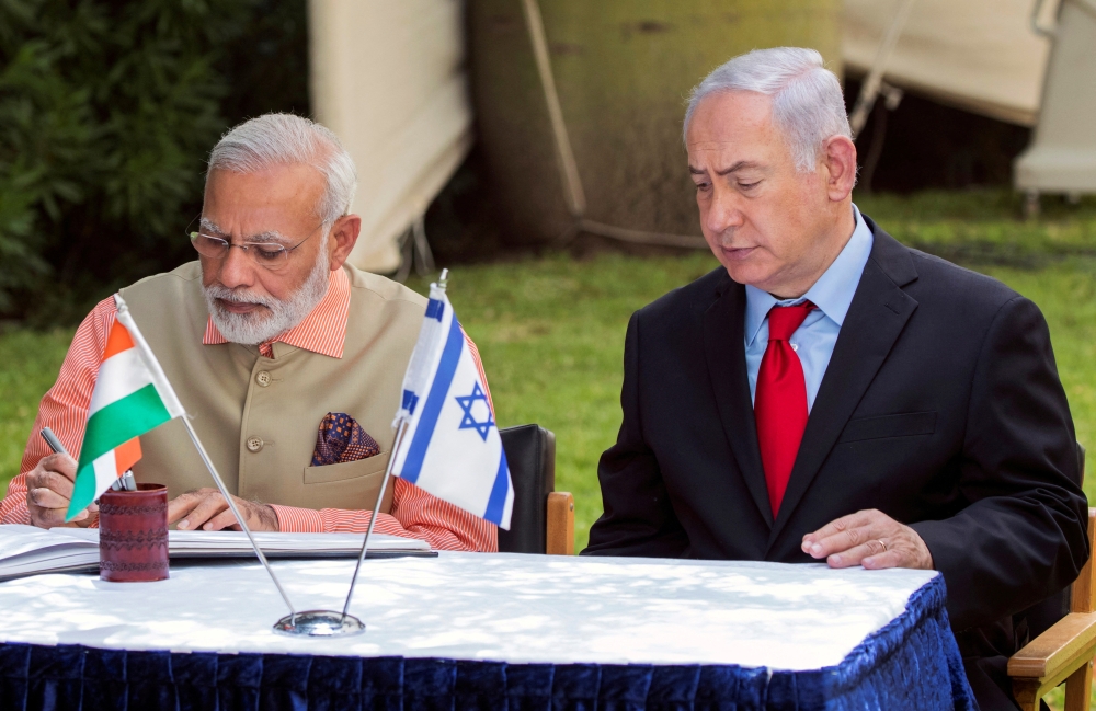 Indian Prime Minister Narendra Modi and Israeli Prime Minister Benjamin Netanyahu sign the guest book at the Indian Army Cemetery of World War I to honour fallen Indian soldiers, in the Israeli coastal city of Haifa July 6, 2017. — AFP pic
