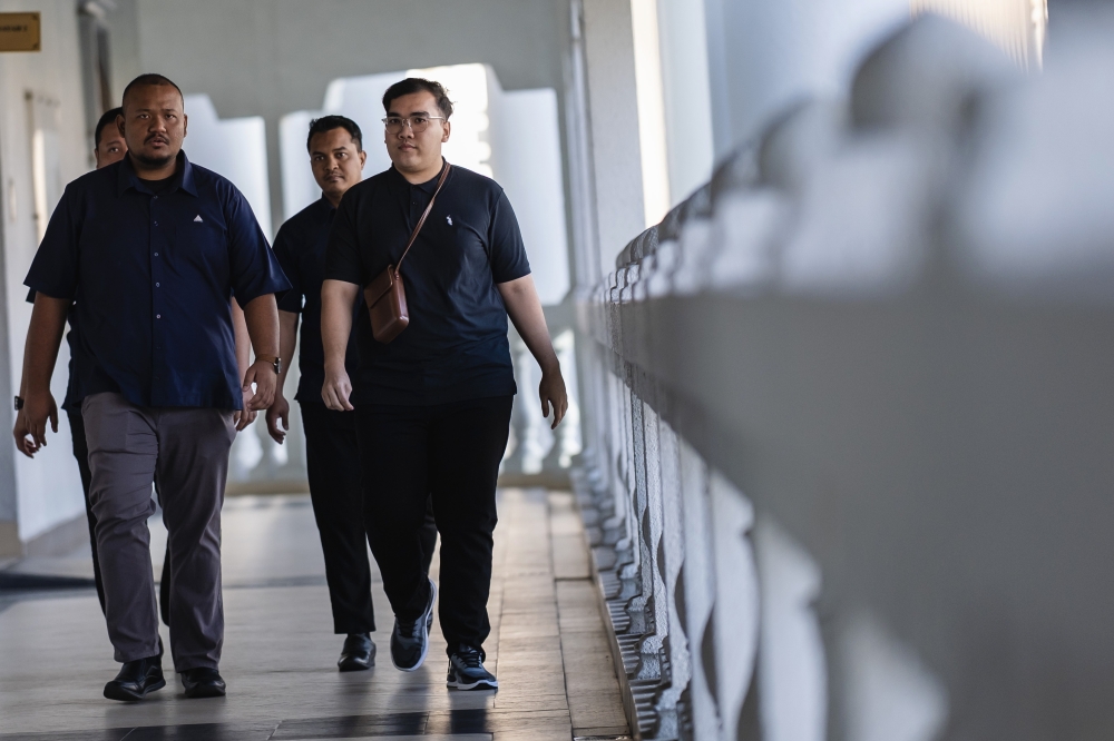 Muhammad Azmirul Iman (right) was charged with knowingly initiating the transmission of obscene video content via the X application under the username ‘a@sweetierosieee’ at 11.32pm on March 29, 2024, with the intent to harass others. — Bernama pic 