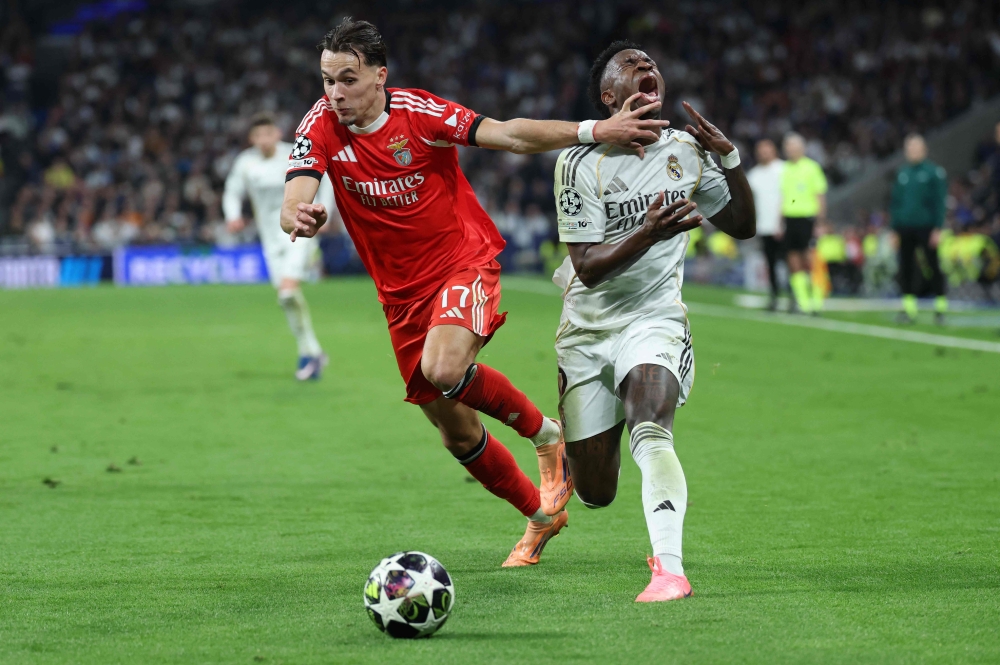 SL Benfica’s Bosnian defender #17 Amar Dedic (left) and Real Madrid’s Brazilian forward #07 Vinicius Junior fight for the ball during the Uefa Champions League knockout round play-off second leg football match between Real Madrid CF and SL Benfica at Santiago Bernabeu Stadium in Madrid on February 25, 2026. — AFP pic 