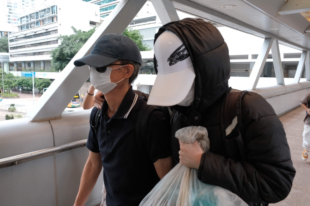 Kwok Yin-sang (left) leaves the High Court after a judge granted him bail in Hong Kong on May 20, 2025. A Hong Kong court sentenced Kwok Yin-sang, 69, the father of activist Anna Kwok, on February 26, 2026, to eight months in prison under a national security law, after he attempted to terminate his daughter's insurance policy and withdraw funds. — AFP pic 