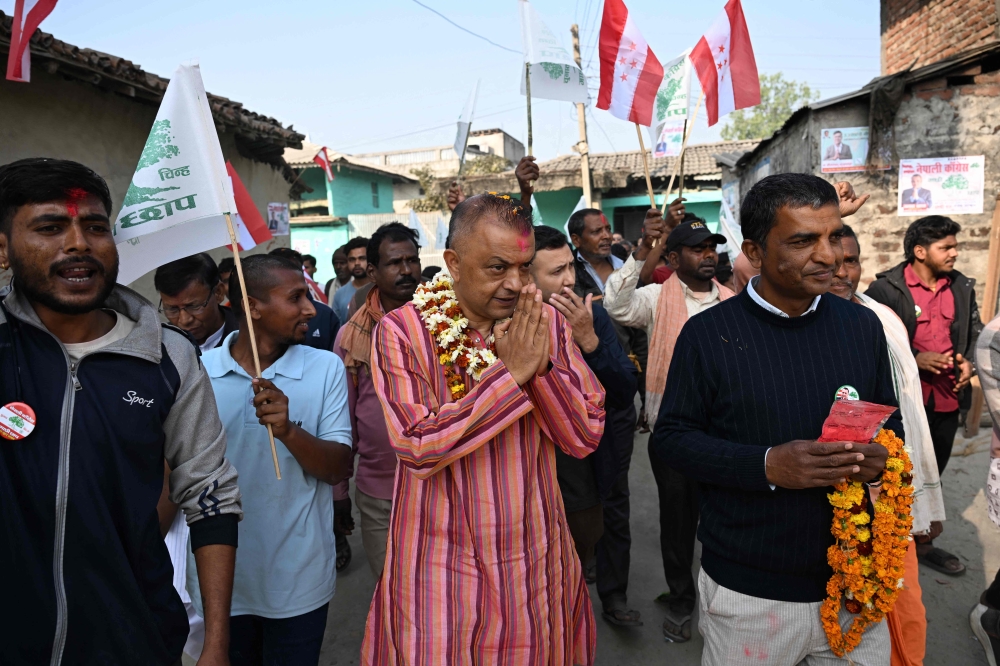 Nepali Congress party’s president and election candidate Gagan Thapa (centre) greets supporters during door-to-door campaign in Sarlahi on February 21, 2026. — AFP pic 