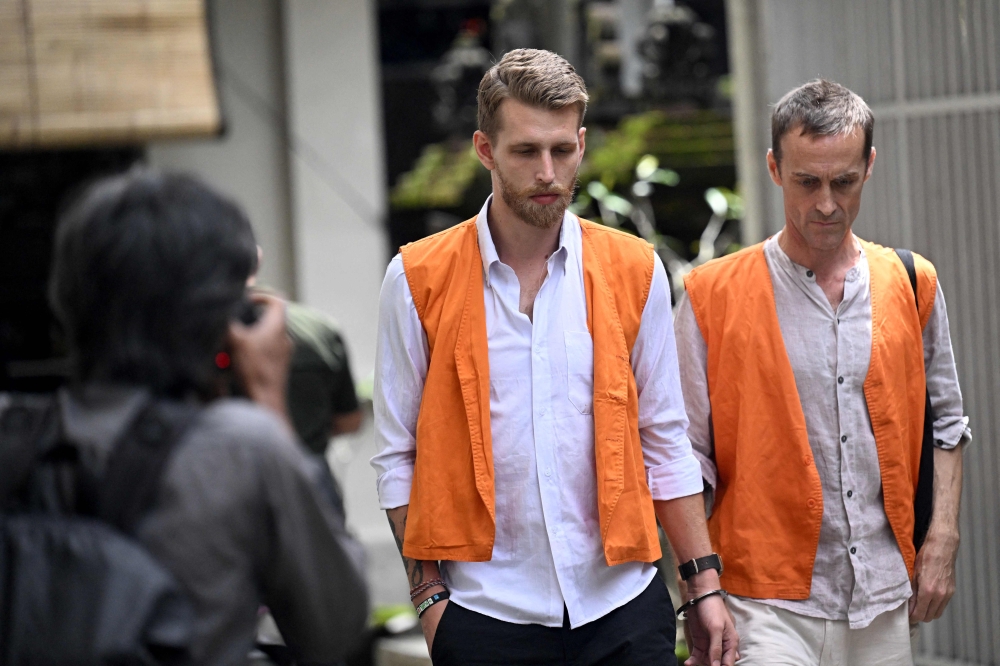 British nationals Kial Garth Robinson (left) and Piran Ezra Wilkinson walk to a court room during their trial in Denpasar on the Indonesian resort island of Bali on February 26, 2026. — AFP pic 