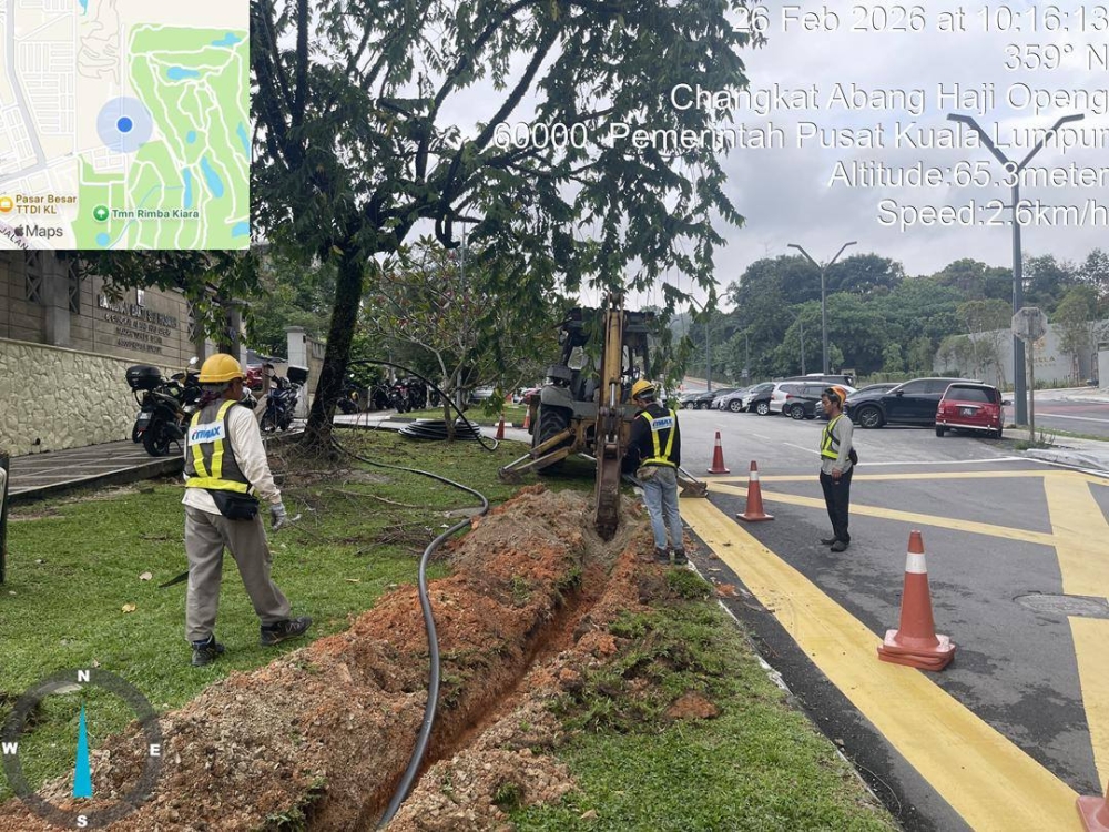 Contractors are seen working to lay cables for the surveillance cameras at Taman Persekutuan Bukit Kiara in Kuala Lumpur. — DBKL pic