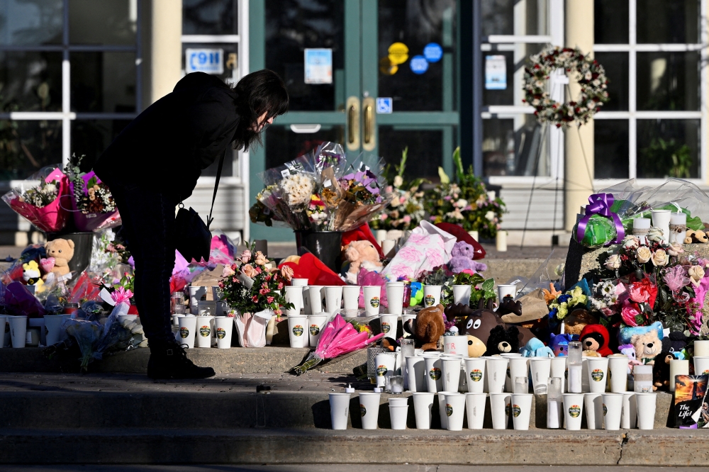 File picture of a woman visiting a growing makeshift memorial on the steps of the town hall, four days after one of the worst mass shootings in recent Canadian history, in the town of Tumbler Ridge, British Columbia, Canada, February 14, 2026. — Reuters pic 