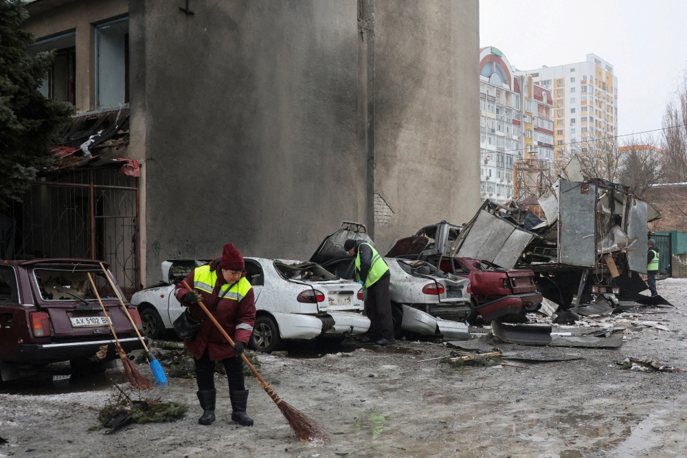 Municipal workers remove debris next to damaged cars outside an apartment building hit by a Russian drone strike on Thursday, amid Russia’s attack on Ukraine, in Kharkiv, Ukraine February 26, 2026. — Reuters pic 