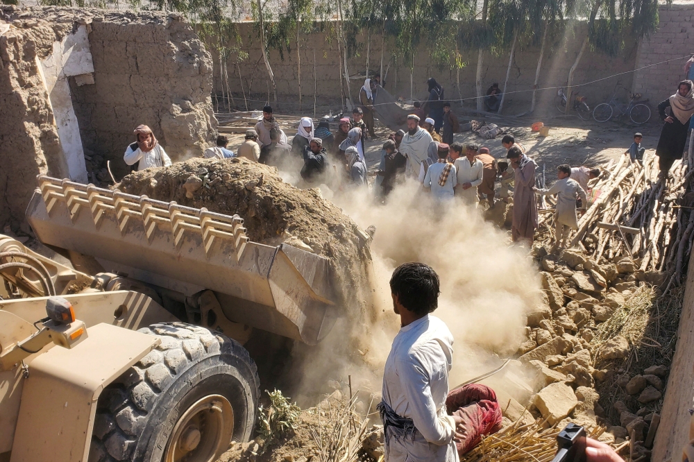 Residents gather as machinery clears the debris of a damaged house, following the Pakistani air strikes, in Nangarhar, Afghanistan, February 22, 2026. — Reuters pic
