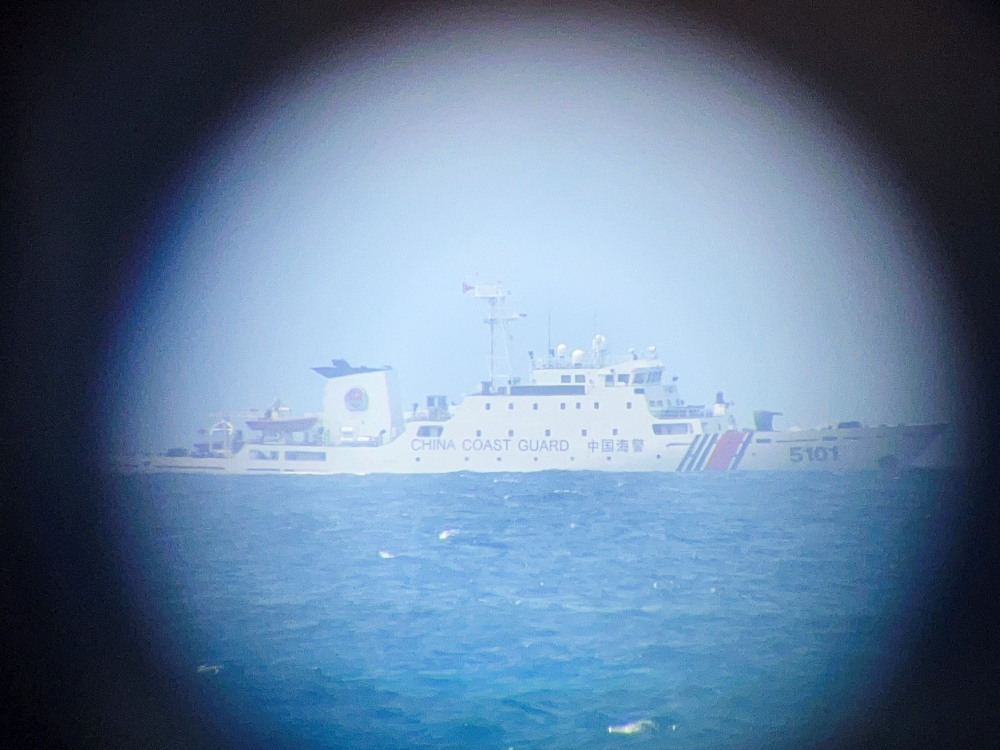 A China Coast Guard ship on the horizon through a telescopic view in Philippine-occupied Thitu Island in the disputed South China Sea, February 21, 2026. Picture taken with a mobile phone. — Reuters pic