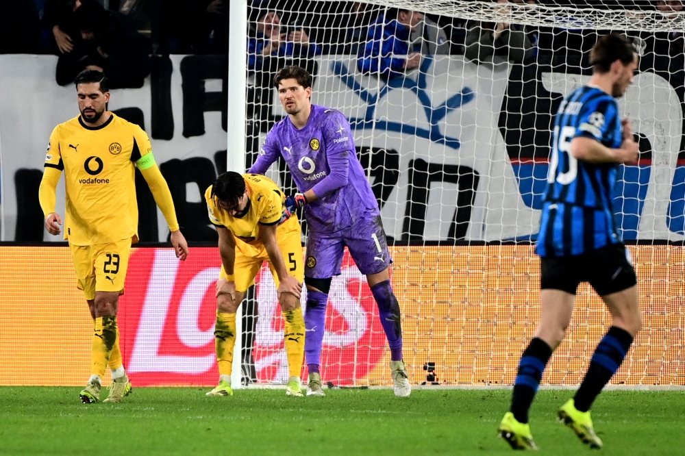 Dortmund’s Algerian defender #05 Ramy Bensebaini (2nd left) and Dortmund’s Swiss goalkeeper #01 Gregor Kobel (2nd right) react after Atalanta scored a second goal during the Uefa Champions League knockout round play-off second leg football match between Atalanta and Borussia Dortmund at the Stadio di Bergamo in Bergamo, on February 25, 2026. — AFP pic 