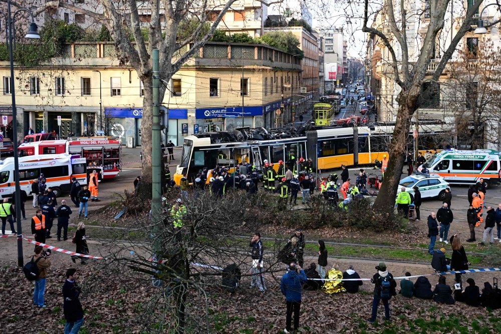 Italian police officers, emergency service teams and firefighters operate at the site of a tram derailment in Milan on February 27, 2026. — AFP pic