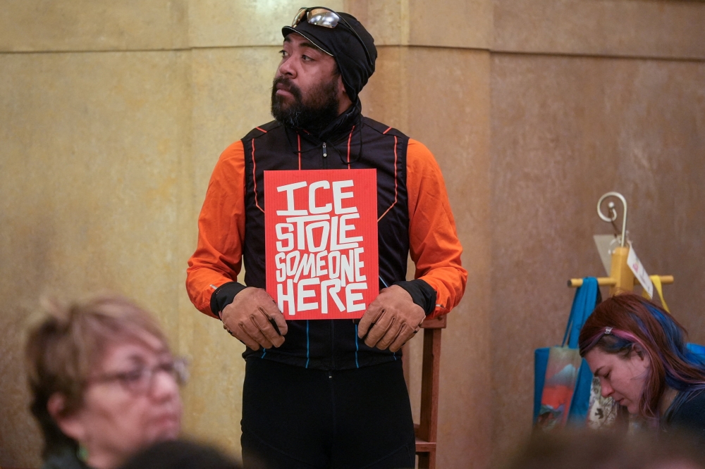 A man holds a placard as protesters gather during an event organised by Unidos MN at Christ Lutheran Church, near the State Capitol, in St. Paul, Minnesota February 26, 2026. — Reuters pic 