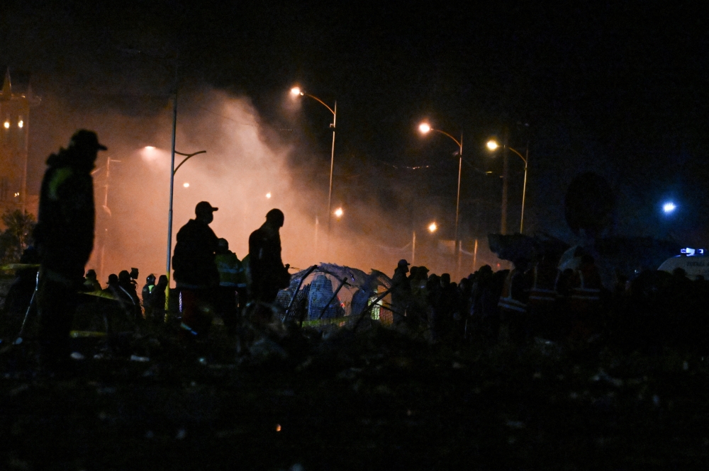People stand at the site where a Bolivian Air Force Hercules aircraft crashed on Friday evening onto a busy avenue amid inclement weather in the city of El Alto, Bolivia, February 27, 2026. — Reuters pic  