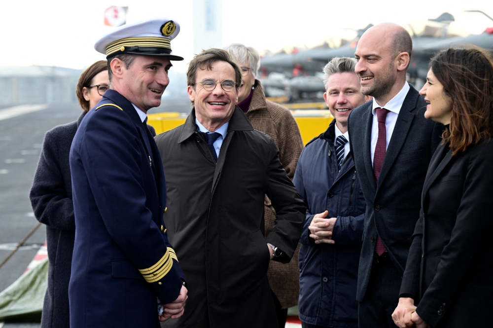 Captain Thomas Puga, Sweden's Prime Minister Ulf Kristersson, France's Minister for Europe and Foreign Affairs Jean-Noel Barrot, Sweden's Minister for Defence Pal Jonson and other officials speak on the day of a bilateral meeting on the French aircraft carrier Charles De Gaulle (R91), in Malmo, Sweden February 27, 2026. — TT News Agency/Johan Nilsson pic via Reuters 