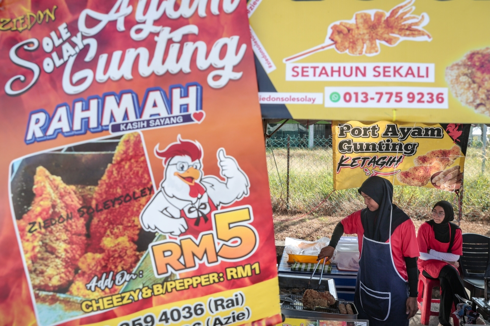 Trader Aziani Mohd Nordin prepares ‘ayam gunting’ for sale at the Bazar Ramadan Rahmah in Taman Wawasan, Mersing, Johor which she sells for RM5 to provide wallet-friendly meals during buka puasa in February 2026. — Bernama pic