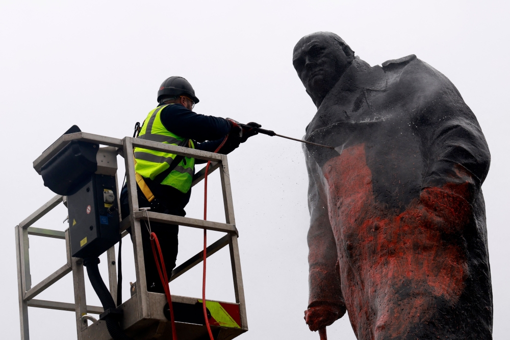 A worker pressure washes graffiti off of a statue of Britain痴 former Prime Minister Winston Churchill in Parliament Square, in central London on February 27, 2026. — AFP pic 