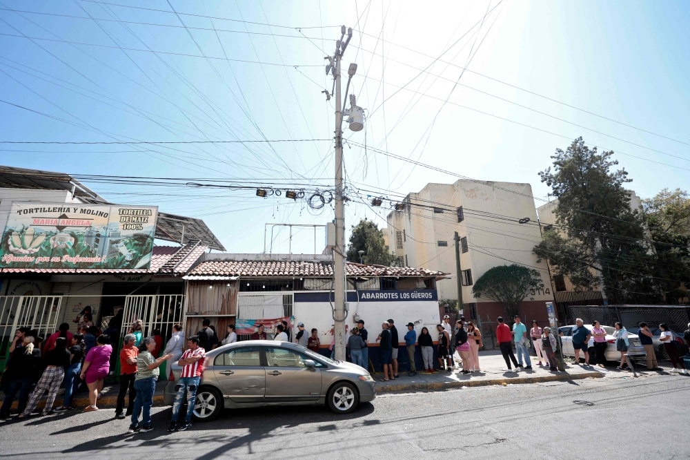 People wait in line outside a tortilla store a day after it was closed due to clashes in Guadalajara, Jalisco, Mexico, on February 23, 2026. — AFP pic