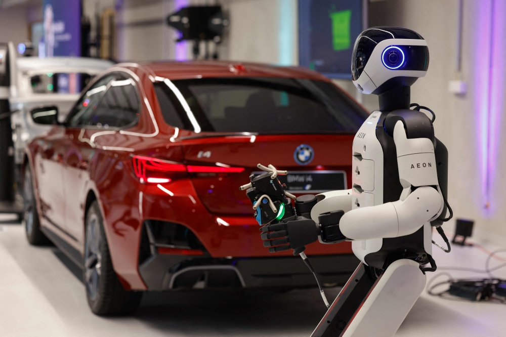 AEON, a humanoid robotic created by the company Hexagon, works on a car with a laser scanner, as it is presented by BMW is presented by BMW, at their BMW Group Talent Campus in Munich, Bavaria, southern Germany, on February 27, 2026. — AFP pic