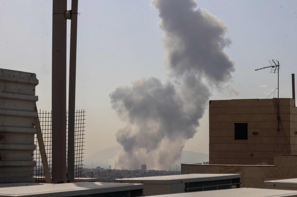 A plume of smoke rises following a reported explosion in Tehran on February 28, 2026. — AFP pic