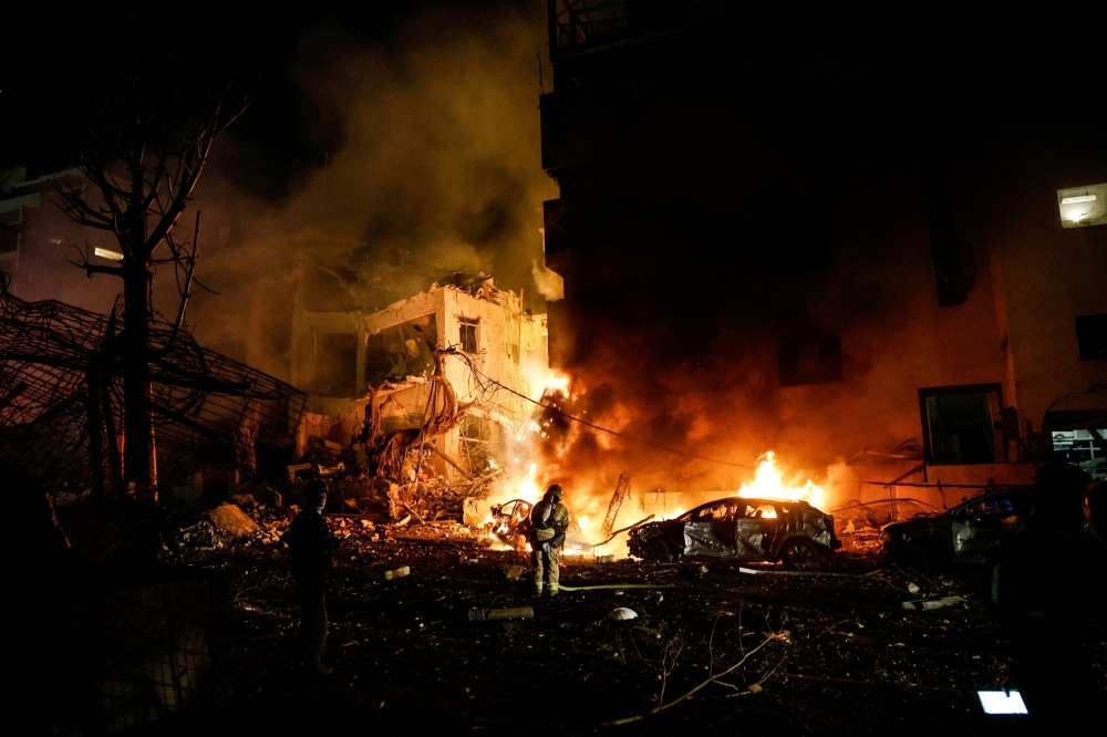 Israeli firefighters work to put out a fire on a car at the site of a projectile impact after Iran launched missiles into Israel, following Israeli and US strikes on Iran, in Tel Aviv, Israel on February 28, 2026. — Reuters pic
