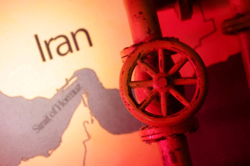 A map showing the Strait of Hormuz and Iran is seen behind a 3D printed oil pipeline on June 22, 2025. — Reuters pic