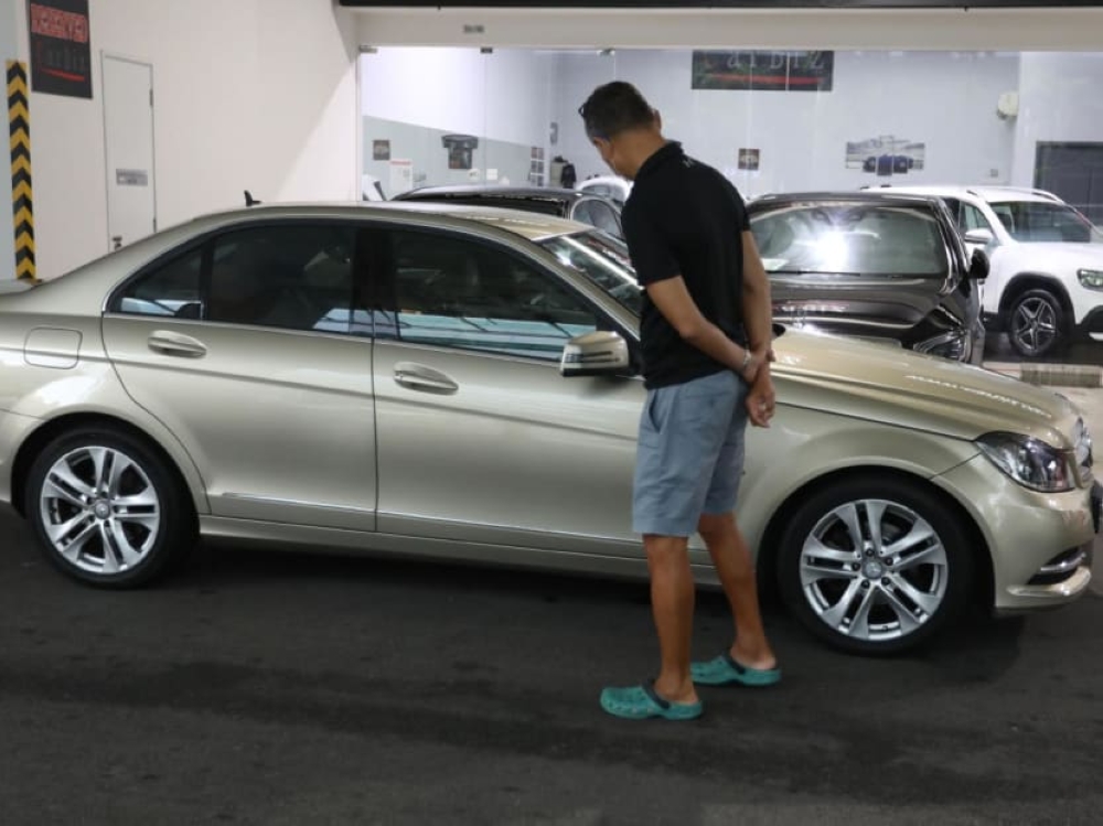 A person views cars being sold in a showroom in Singapore. — TODAY pic