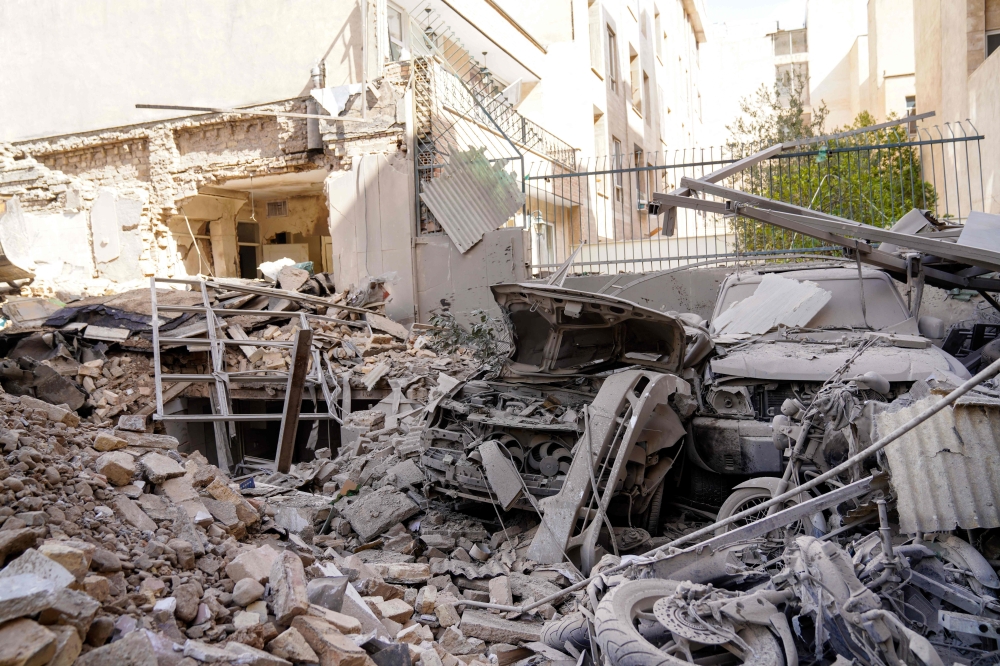 Rubble and debris cover a destroyed vehicle following a missile strike on a neighbourhood of the Iranian capital Tehran on February 28, 2026. — AFP pic