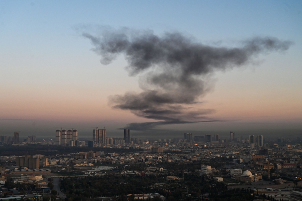 A plume of smoke rises near Erbil International Airport in Erbil on March 1, 2026. — AFP pic