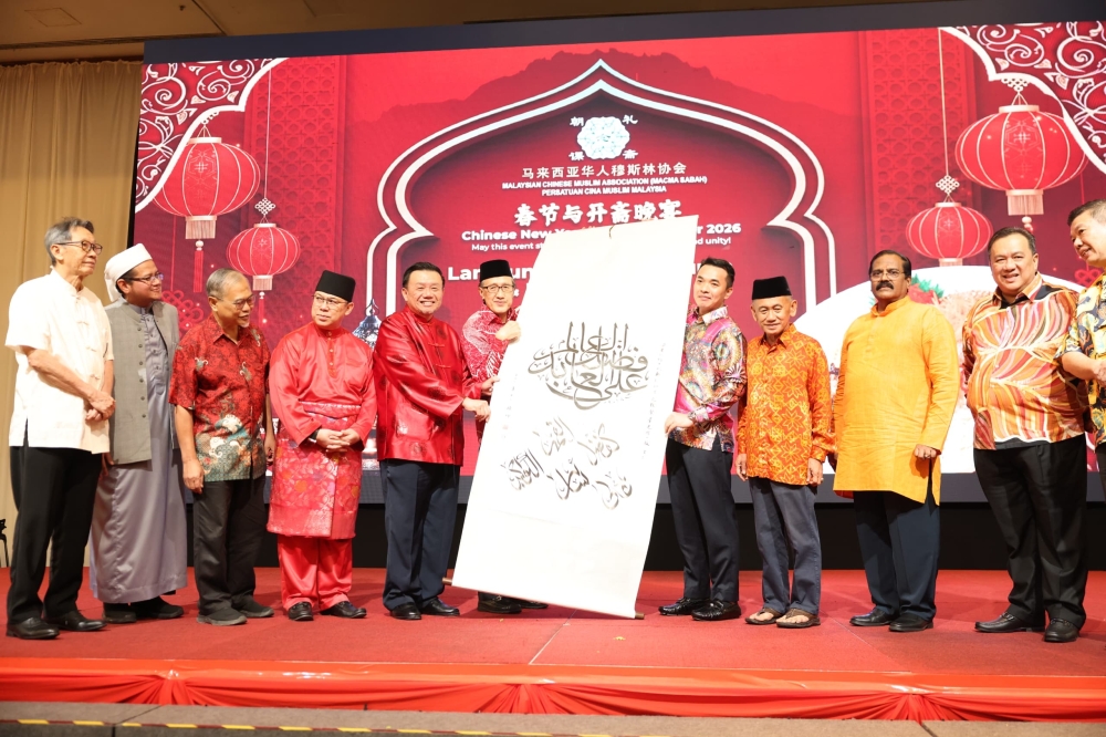 Masidi (sixth left) receiving an Islamic calligraphy as a souvenir from the organising committee on February 28, 2026. — The Borneo Post pic