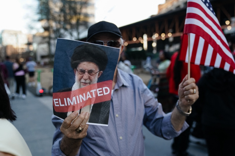 A man holds a US flag and a sign with a portrait of Iranian Supreme Leader Ayatollah Ali Khamenei reading ‘eliminated’ during a rally expressing support for US and Israeli military action against Iran’s Islamic Republic government on February 28, 2026 in Atlanta, Georgia. — AFP pic