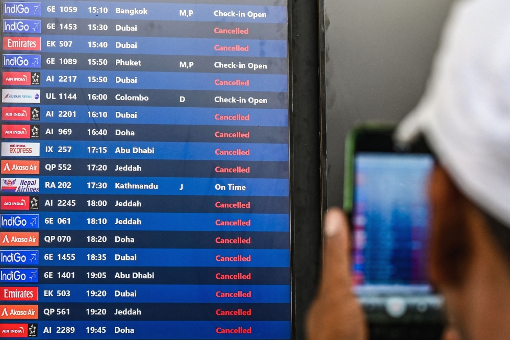 A passenger takes pictures of a flight information board at the Chhatrapati Shivaji Maharaj International Airport in Mumbai on March 1, 2026 after India's two largest private carriers IndiGo and Air India suspended flights to all destinations in the Middle East. Thousands of flights have been delayed or cancelled in the biggest disruption to global air transport since the Covid pandemic as airlines suspend services to the Middle East following the US and Israeli attacks on Iran. — AFP pic 