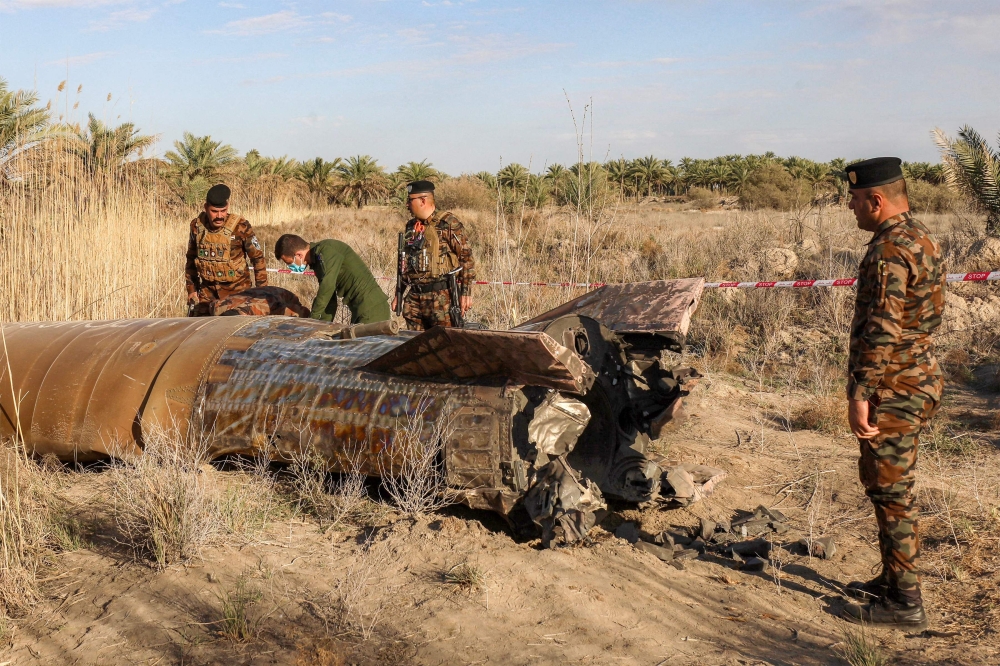 Members and officers from the Iraqi Interior Ministry's Explosives Directorate inspect the fuel tank of a rocket that landed in a rural village in the Siyahi area near the city of Hilla in the central Babil province on March 1, 2026. New strikes hit an Iraqi military base housing Kataeb Hezbollah, a source from the pro-Iran armed group said today. — AFP pic 