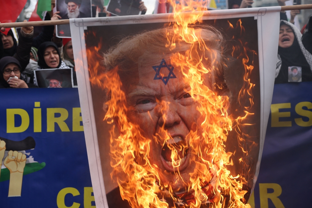Demonstrators set fire to a placard with a depiction of US President Donald Trump during a protest against Israel and the US strikes on Iran outside the Israeli consulate in Istanbul, Turkey on March 1, 2026. — Reuters pic