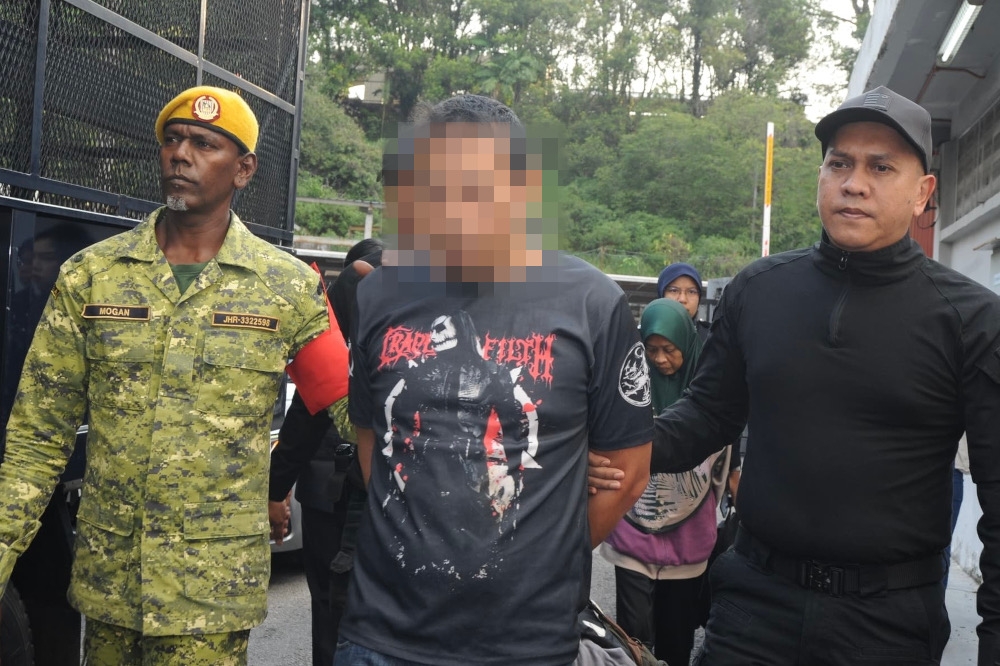 A school security guard was charged in the Sessions Court here today with 13 offences, including sodomy, sexual assault and rape of his six-year-old daughter in January and February this year. — Picture by Ben Tan