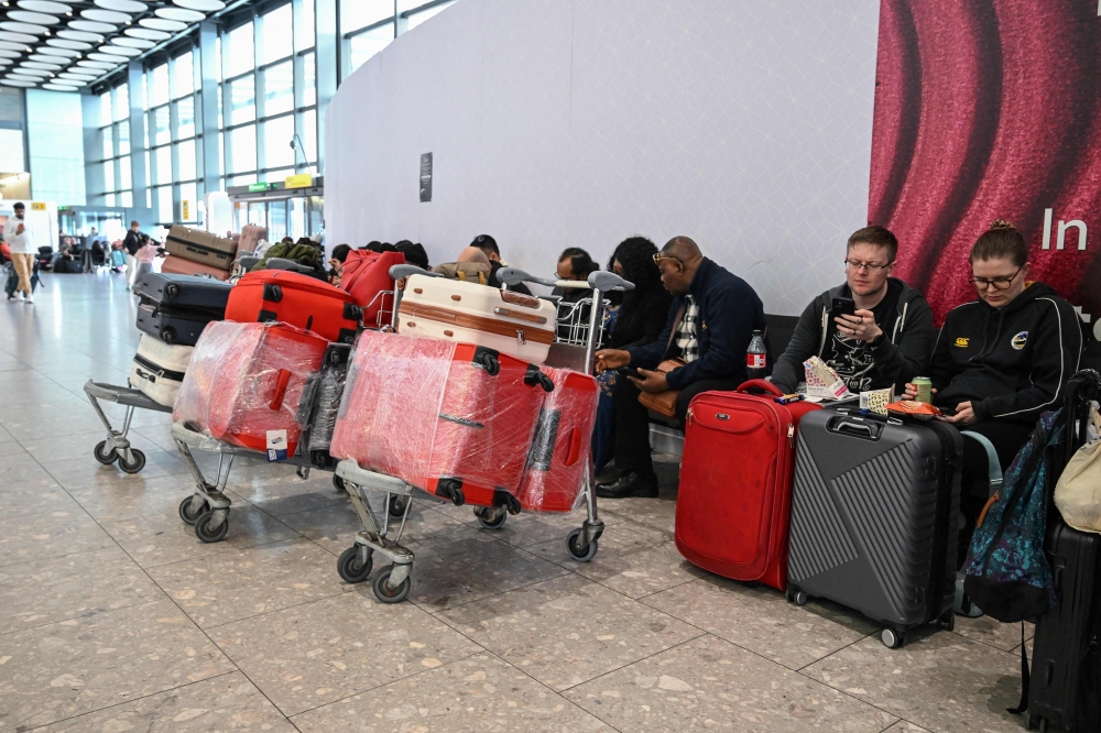 Passengers sit waiting for news about flights at Terminal 4 at London Heathrow Airport in west London on March 1, 2026, as flights are severely disrupted following the US and Israel's strikes on Iran. — AFP pic
