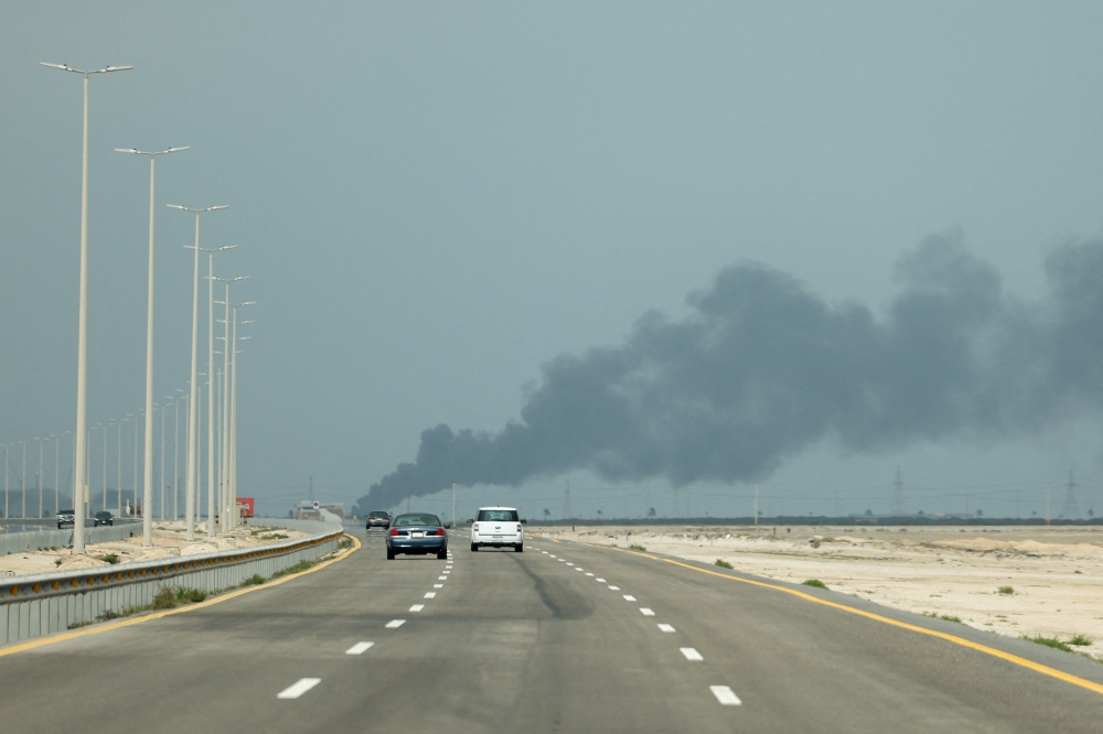 Vehicles move along a road as smoke billows from Saudi Aramco's Ras Tanura oil refinery after a reported Iranian drone strike, amid the US-Israel conflict with Iran, in Ras Tanura, Saudi Arabia, March 2, 2026. — Reuters pic