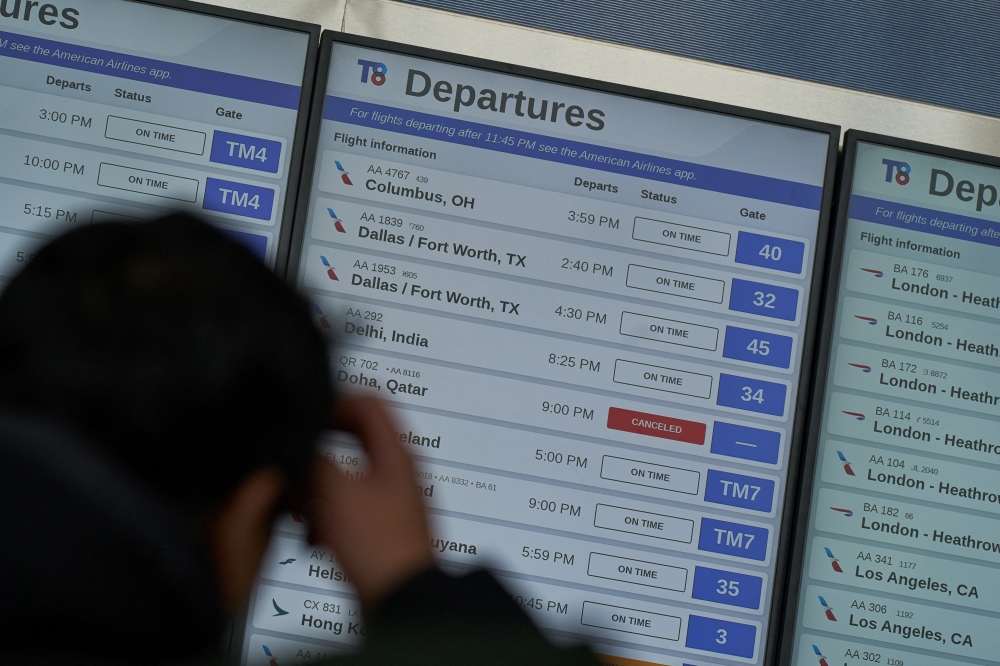 A traveler looks at a departures board displaying a cancelled Qatar Airways flight for Doha, amid the US-Israel conflict with Iran, at Terminal 8 at John F. Kennedy (JFK) International Airport in New York March 2, 2026. — Reuters pic 