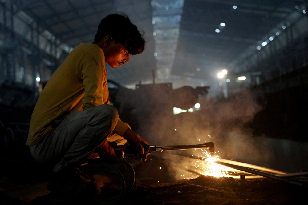 A worker welds a steel bar at a steel processing production line of a factory in Mandi Gobindgarh, in the northern state of Punjab, India. — Reuters pic