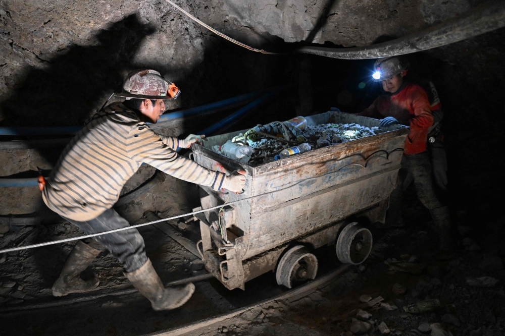 Miners push a wagon loaded with extracted minerals inside a tunnel of the Rosario Bajo Cooperativa Minera on Cerro Rico, in the Potosi Department, in southern Bolivia on February 19, 2026. — AFP pic