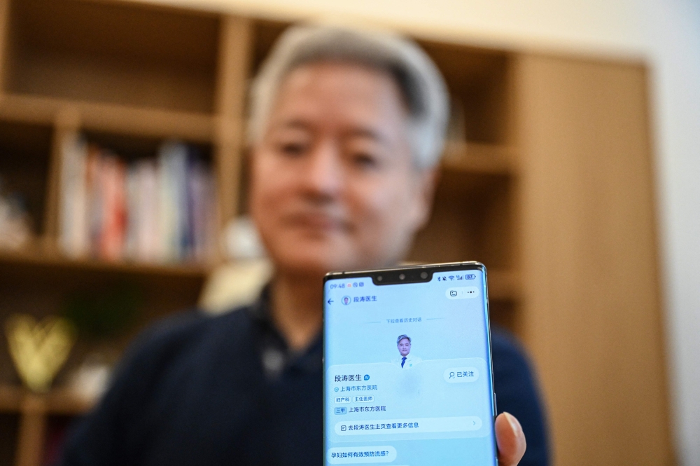 Doctor Duan Tao shows his AI avatar on the healthcare app AQ at his office at a hospital in Shanghai on February 11, 2026. — AFP pic