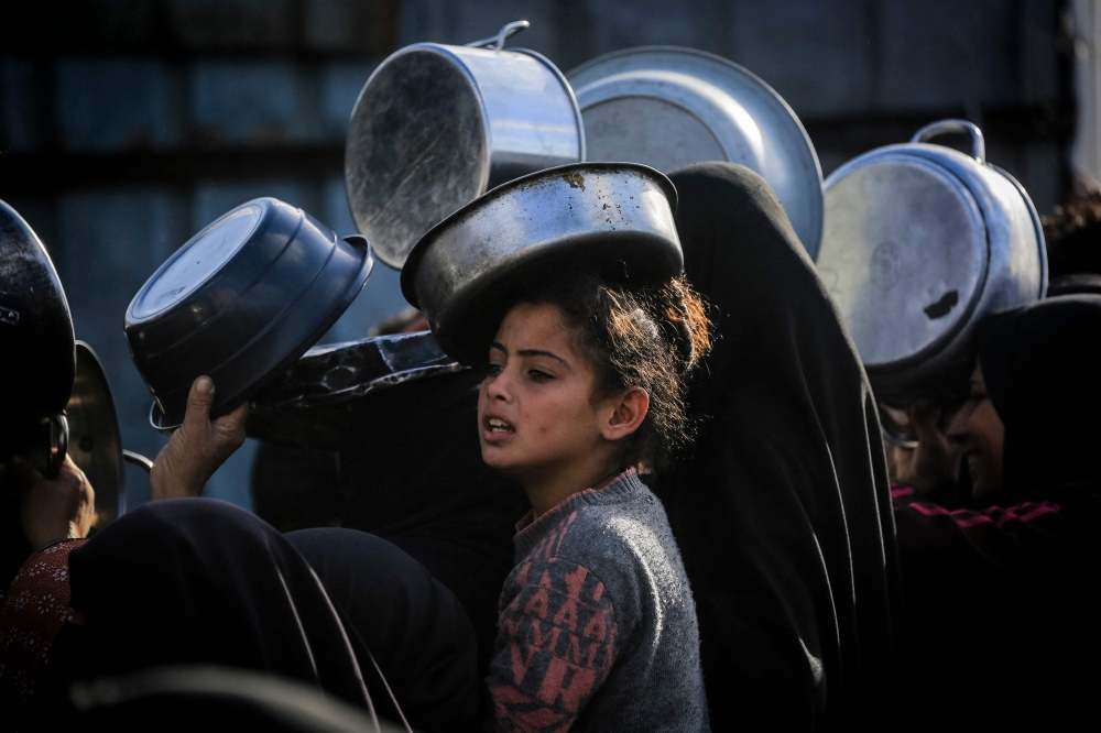 Palestinians wait to receive food at a soup kitchen in Khan Yunis, in the southern Gaza Strip on February 26, 2026. — AFP pic