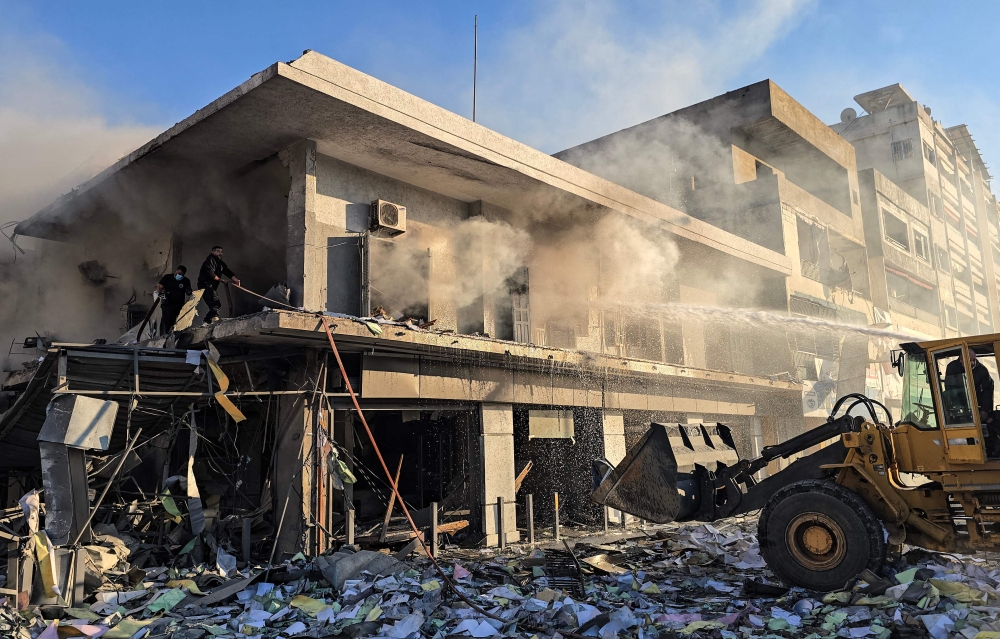 Firefighters work to extinguish a fire at the site of an Israeli airstrike that targeted the offices of Al-Qard al-Hassan, a Hezbollah-linked financial institution, in the southern coastal Lebanese city of Tyre on March 2, 2026. — AFP pic