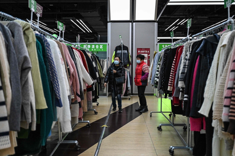 The photo taken on February 10, 2026 shows people browsing through the clothes section at a second-hand store in Shanghai. — AFP pic 