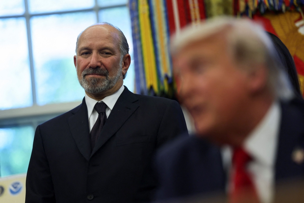 US Secretary of Commerce Howard Lutnick listens to US President Donald Trump speak during an evento to sign executive orders in the Oval Office at the White House in Washington, D.C. April 23, 2025. — Reuters pic  