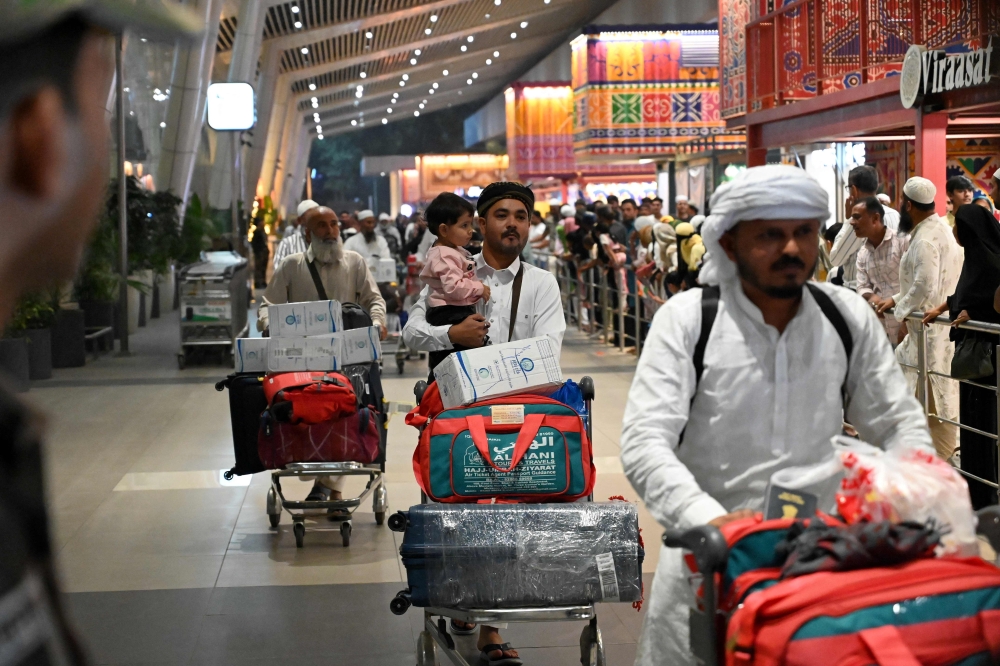 Indian Muslim passengers arrive at the airport of Ahmedabad on late March 3, 2026, after they were stranded in Jeddah (Saudi Arabia) as they visited for special prayer in ongoing Ramadan month, following the eruption of a regional conflict sparked by Israel-US strikes on Iran. Governments and airlines scrambled on March 3, 2026 to repatriate tens of thousands of travellers stranded in the Middle East. — AFP pic 