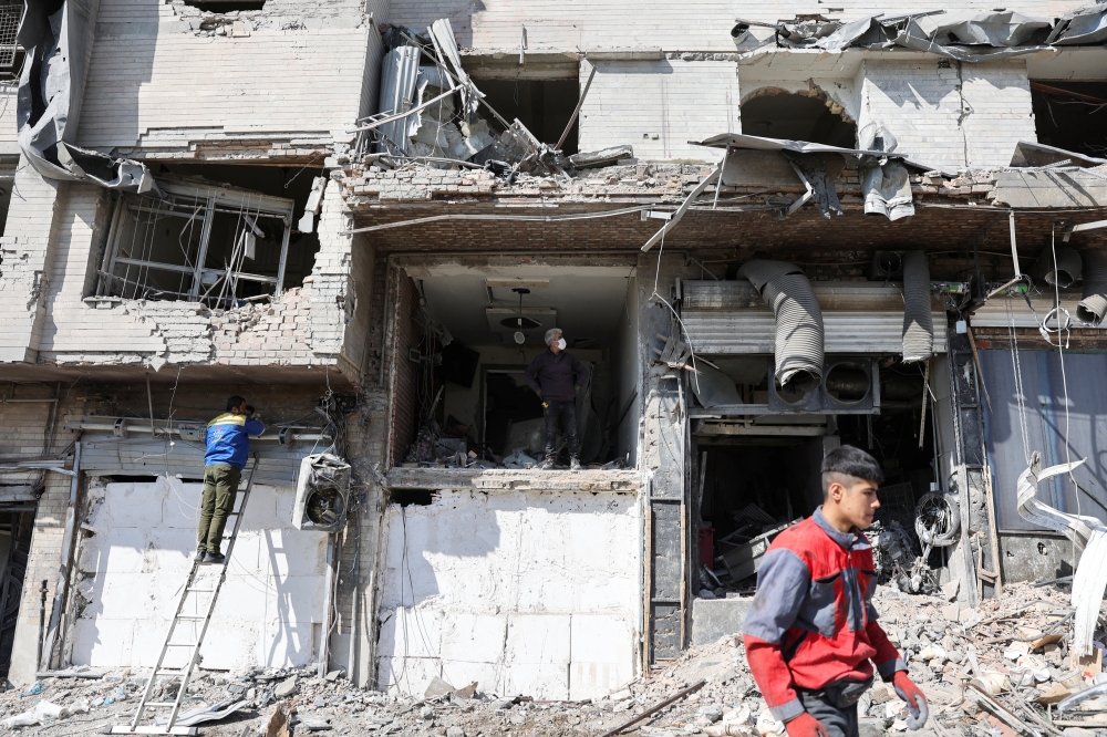 People inspect a damaged building, in the aftermath of a strike on a police station, amid the US-Israeli conflict with Iran, in Tehran March 4, 2026. — Majid Asgaripour/Wana (West Asia News Agency) pic via Reuters